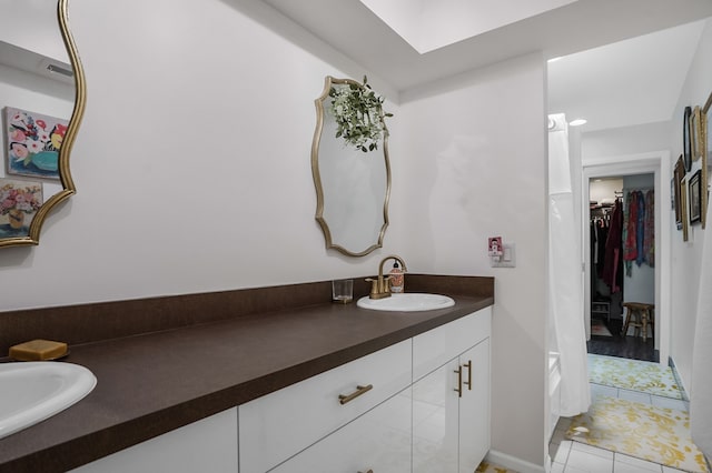 full bathroom featuring vanity, tile patterned floors, a walk in closet, and visible vents