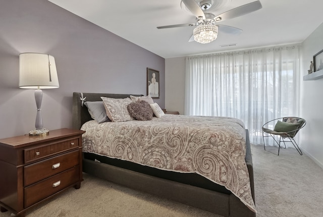 bedroom with visible vents, light colored carpet, and ceiling fan