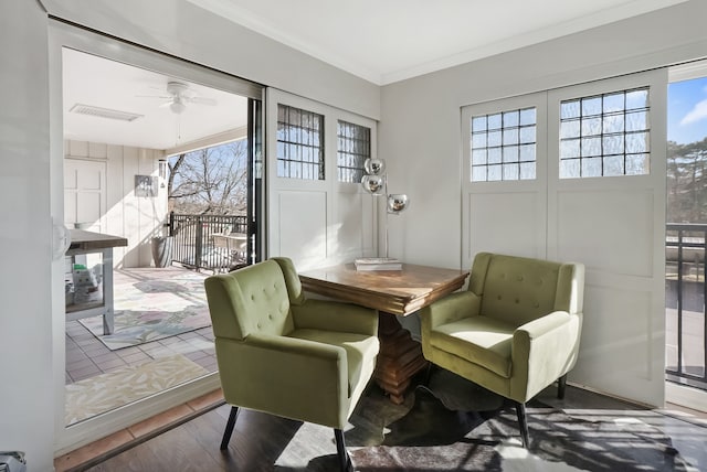 sitting room featuring crown molding, wood finished floors, a ceiling fan, and visible vents