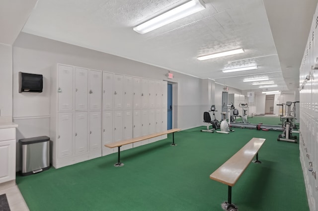 exercise room featuring a textured ceiling and carpet floors