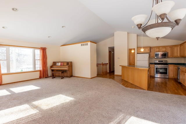 kitchen featuring visible vents, vaulted ceiling, appliances with stainless steel finishes, carpet flooring, and open floor plan