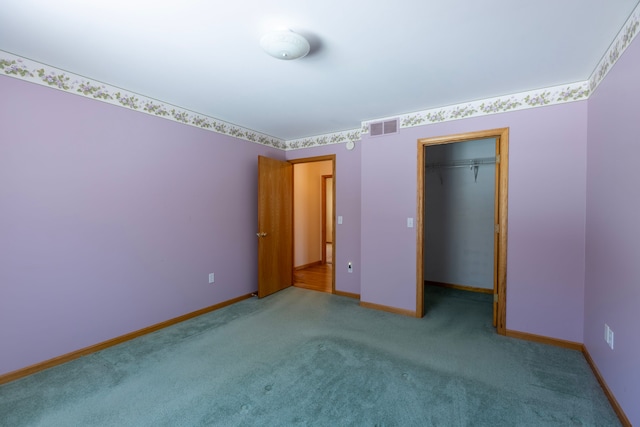 unfurnished bedroom featuring visible vents, light carpet, a closet, baseboards, and a spacious closet