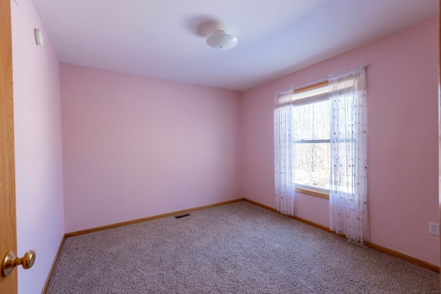 carpeted spare room with visible vents and baseboards