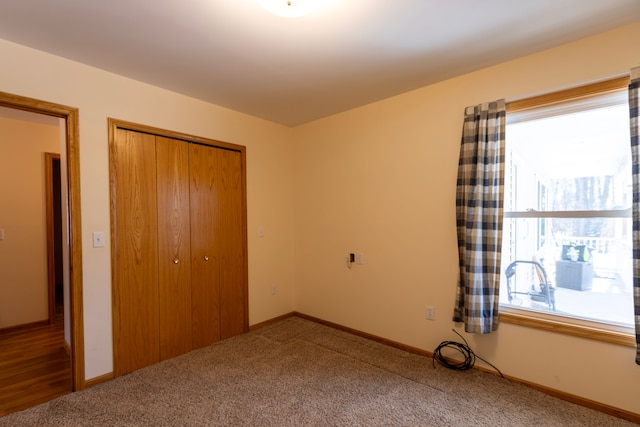 unfurnished bedroom featuring a closet, baseboards, and carpet