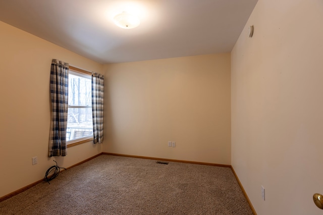 carpeted spare room with baseboards and visible vents