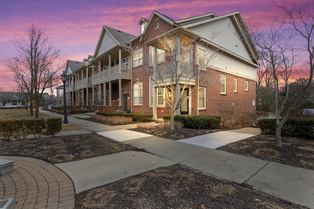 exterior space featuring brick siding and a balcony