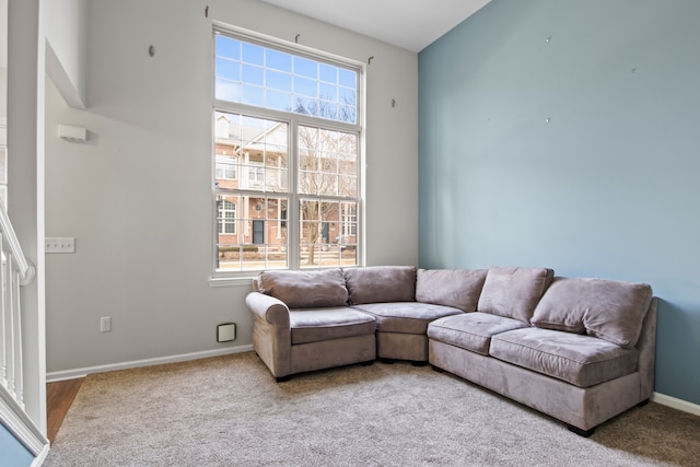 carpeted living area featuring baseboards