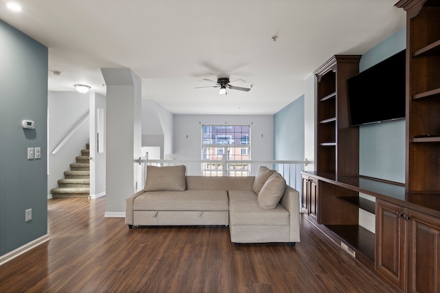 living room with dark wood-style floors, baseboards, and ceiling fan