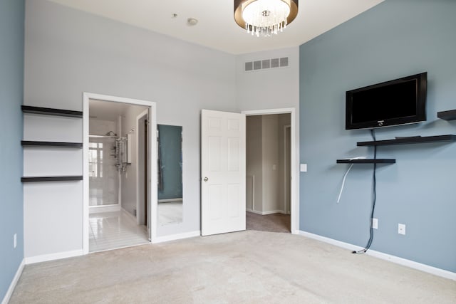 unfurnished bedroom featuring a chandelier, carpet flooring, baseboards, and visible vents