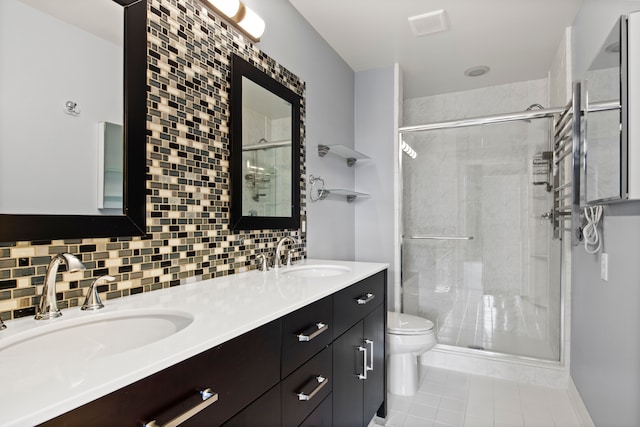 bathroom with a shower stall, toilet, backsplash, and a sink