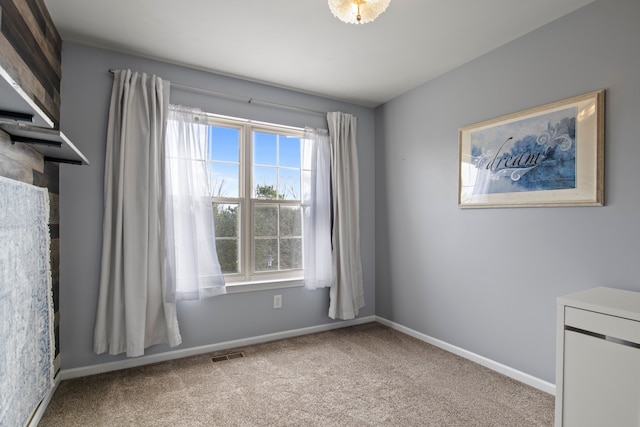 carpeted empty room featuring visible vents and baseboards