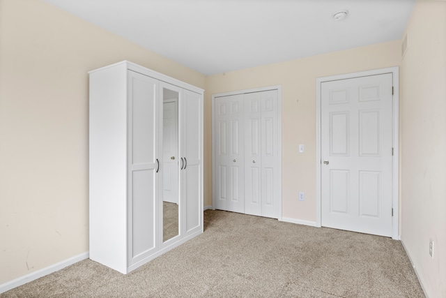 unfurnished bedroom featuring a closet, visible vents, baseboards, and carpet