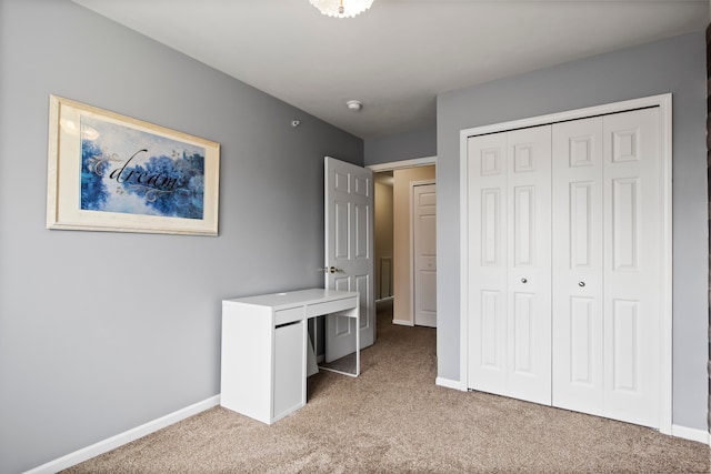 unfurnished bedroom with baseboards, light carpet, and a closet