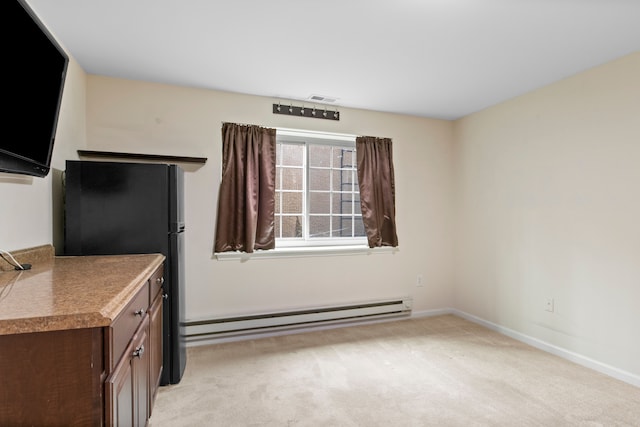 interior space with baseboards, visible vents, a baseboard radiator, freestanding refrigerator, and light carpet