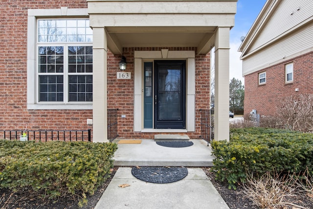 view of exterior entry with crawl space and brick siding