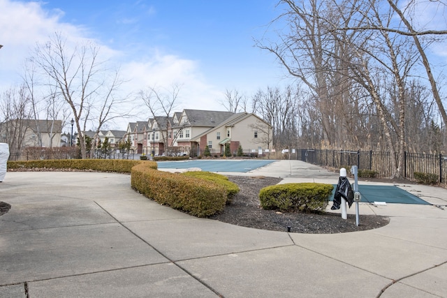 exterior space with a residential view, a pool, and fence