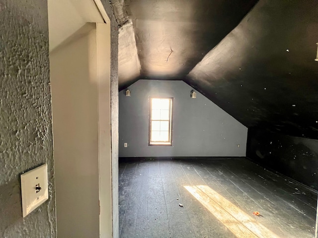 additional living space with wood-type flooring and vaulted ceiling