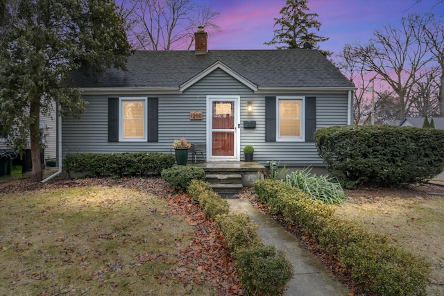 view of front of property with a chimney and a shingled roof