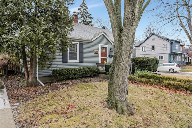 view of front of property featuring roof with shingles and a chimney