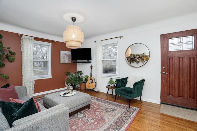 living area with plenty of natural light, light wood-style floors, and baseboards