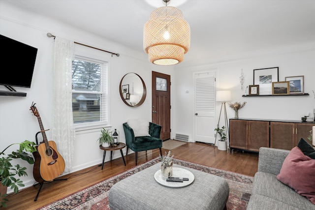 living room featuring visible vents, wood finished floors, and baseboards