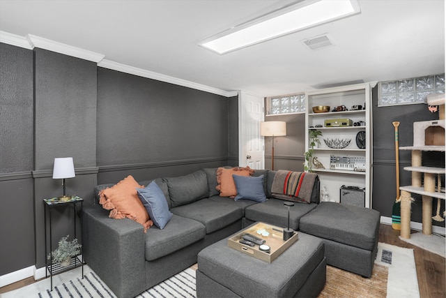 living area featuring visible vents, ornamental molding, and wood finished floors