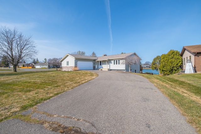 ranch-style house with aphalt driveway, a garage, and a front lawn