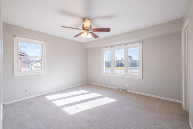 unfurnished room featuring ceiling fan, baseboards, visible vents, and light carpet