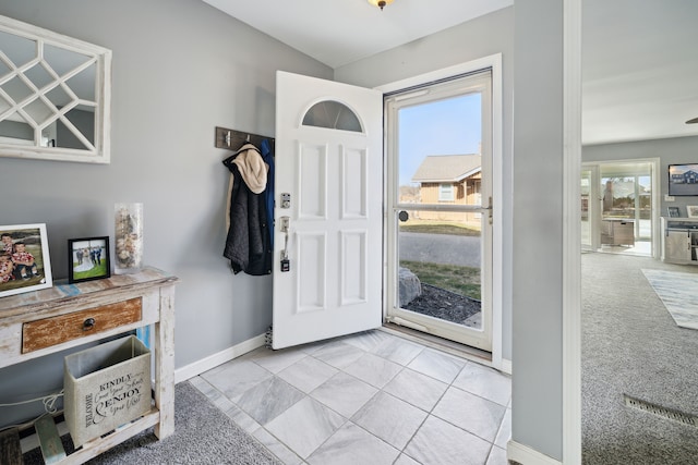 foyer featuring carpet flooring and baseboards