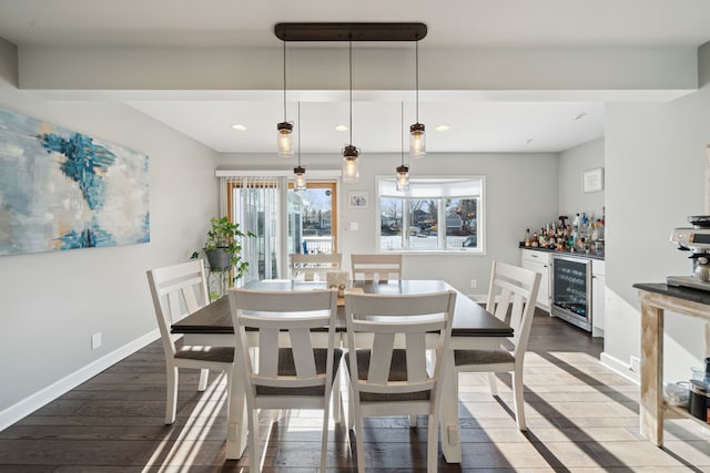 dining room with baseboards, wine cooler, recessed lighting, wood finished floors, and a bar