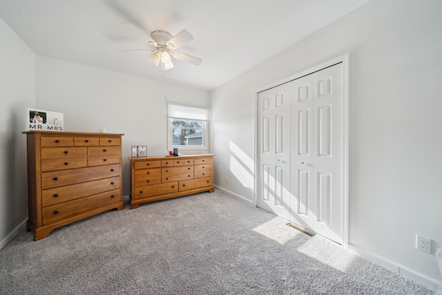 bedroom featuring visible vents, a closet, carpet floors, baseboards, and ceiling fan