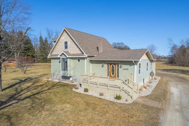 view of front of home featuring a front yard, a porch, driveway, and roof with shingles