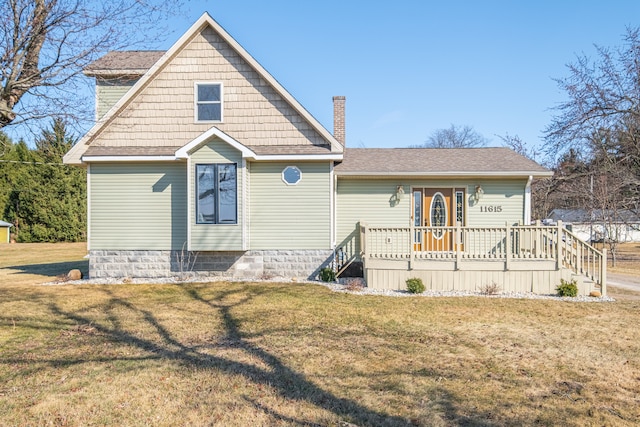 view of front of house with roof with shingles, a chimney, and a front yard