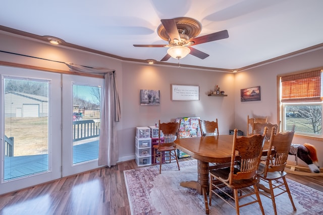 dining space featuring baseboards, wood finished floors, a ceiling fan, and ornamental molding