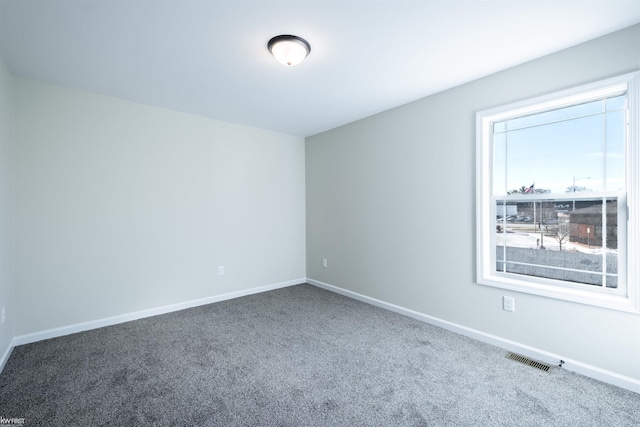 carpeted spare room with baseboards and visible vents