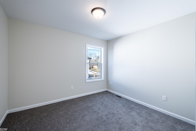 unfurnished room featuring baseboards and dark carpet