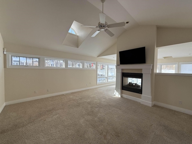 unfurnished living room featuring carpet flooring, a ceiling fan, a multi sided fireplace, and a wealth of natural light