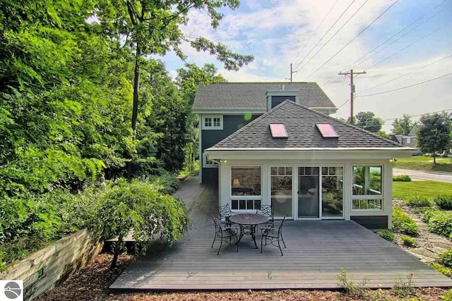 rear view of house with a wooden deck and a shingled roof