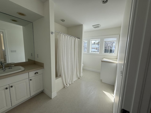 bathroom with shower / bathtub combination with curtain, baseboards, toilet, and vanity