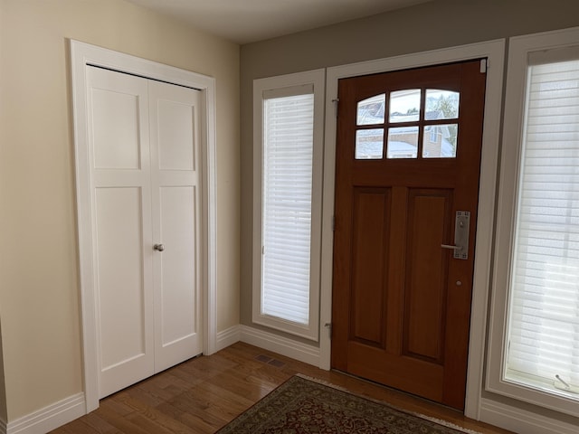 entrance foyer with visible vents, baseboards, and wood finished floors