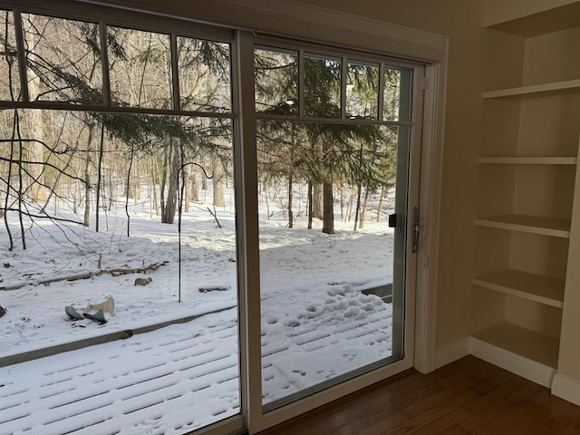 doorway to outside with built in features, baseboards, and dark wood-style flooring