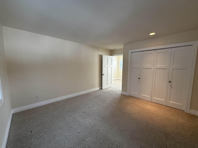 unfurnished bedroom with recessed lighting, a closet, baseboards, and light carpet