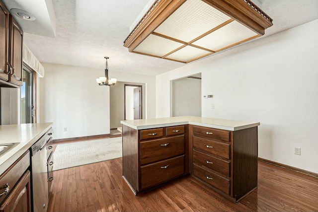 kitchen featuring dark brown cabinets, a center island, dark wood-type flooring, dishwasher, and light countertops