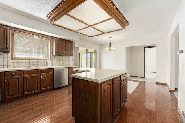 kitchen featuring dark wood-style floors, a sink, backsplash, and stainless steel dishwasher