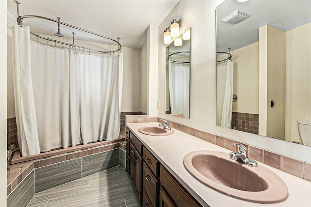 full bathroom with double vanity, visible vents, shower / bath combination with curtain, and a sink