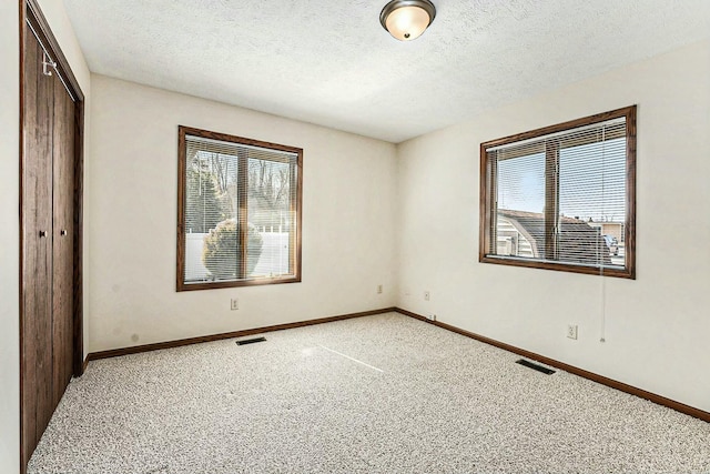 unfurnished bedroom with light colored carpet, visible vents, a closet, and baseboards