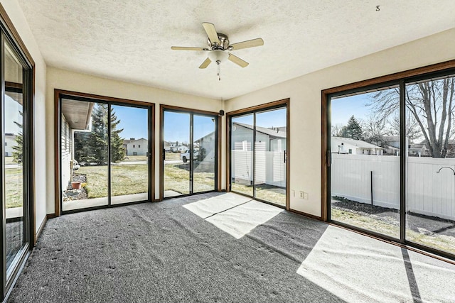 unfurnished sunroom with a ceiling fan