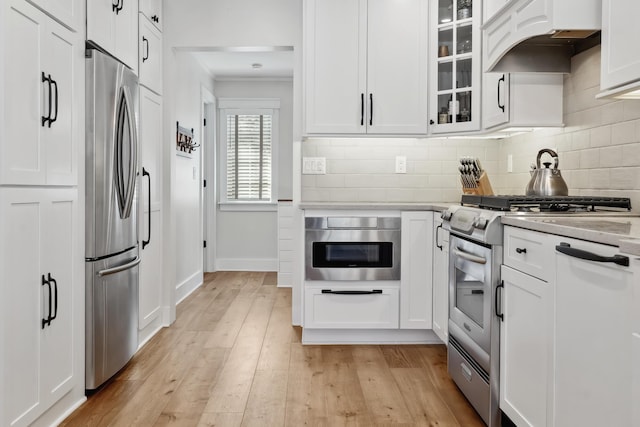 kitchen with under cabinet range hood, white cabinets, and appliances with stainless steel finishes