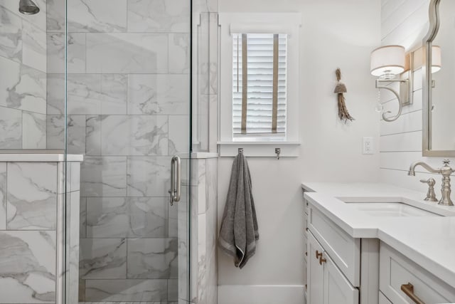 bathroom with a marble finish shower and vanity