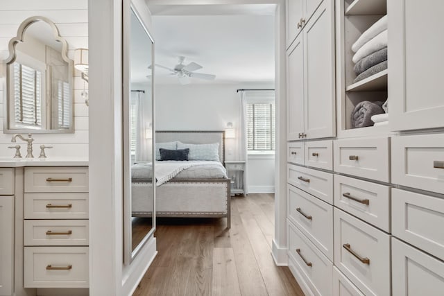 interior space featuring baseboards, light wood finished floors, and a sink